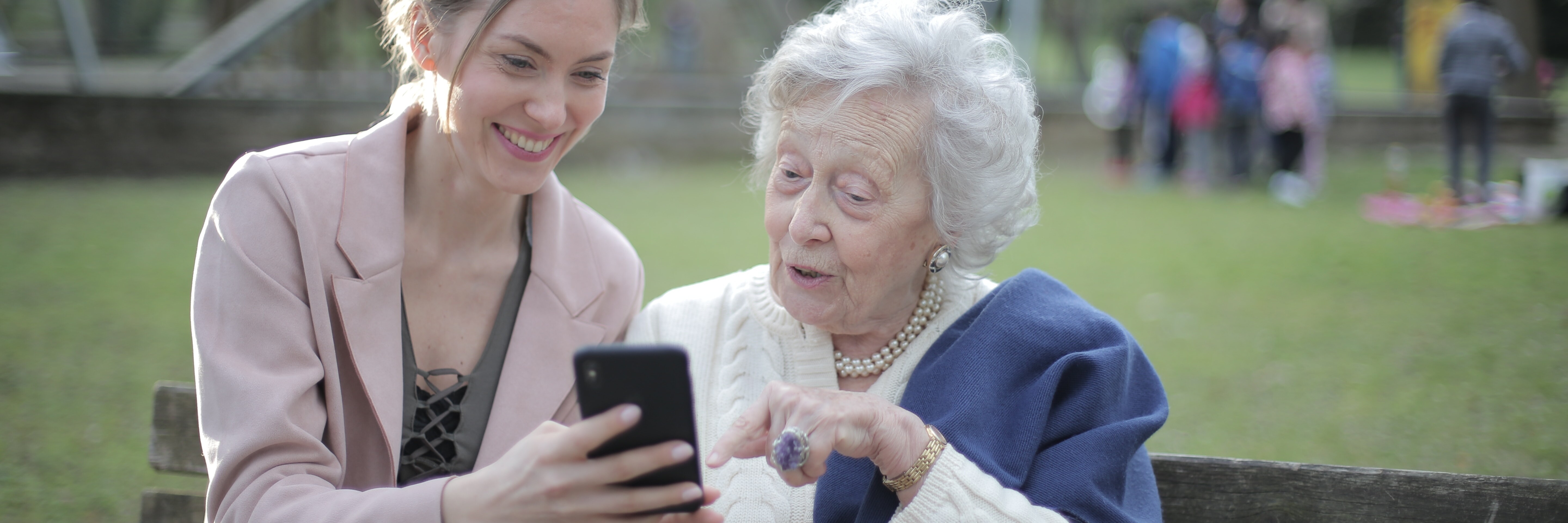 Caregiver and elderly woman looking at a phone