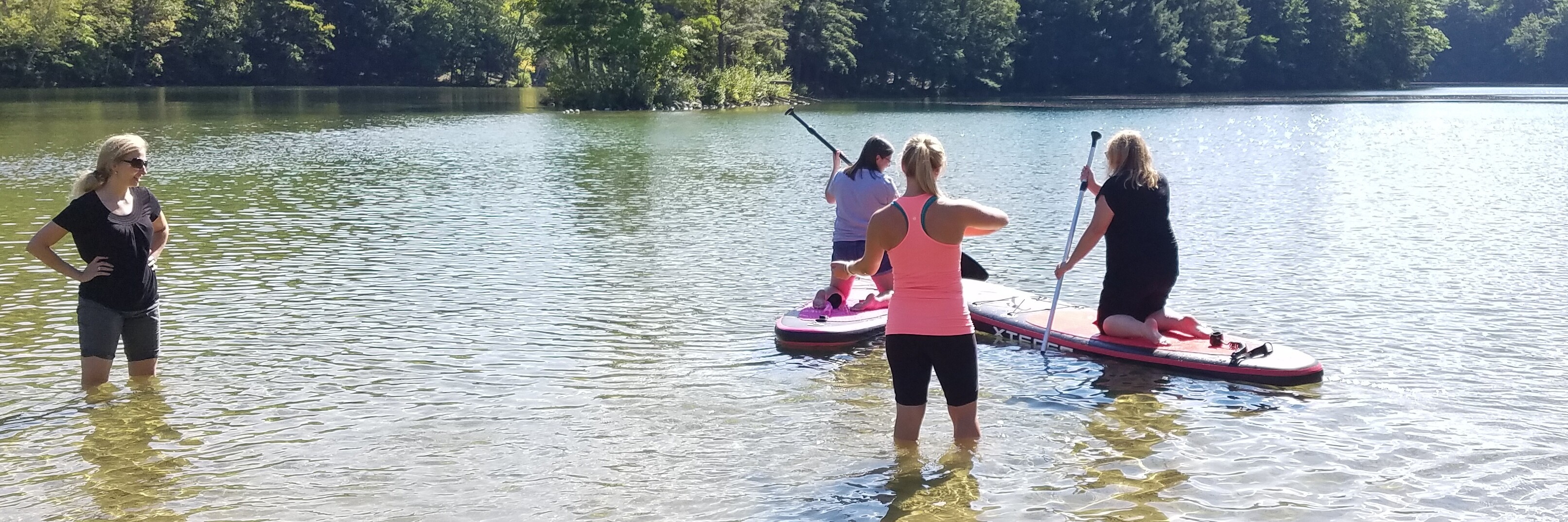 Caregivers paddle boarding in lake 